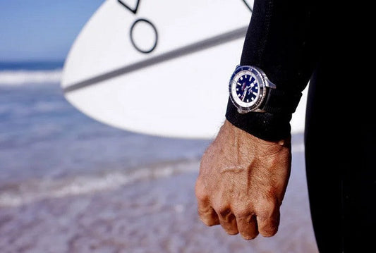 Horloge om pols bij een surfer, risico op krassen door zand